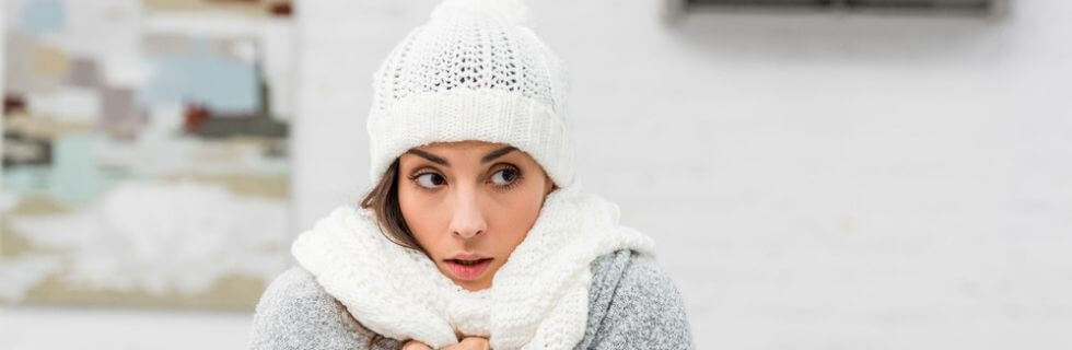 A woman in a scarf and beanie looking cold