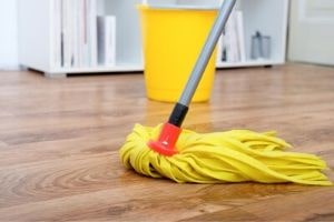 Yellow mop and bucket on wood floor