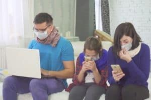 A father, mother, and their daughter wearing face masks indoors